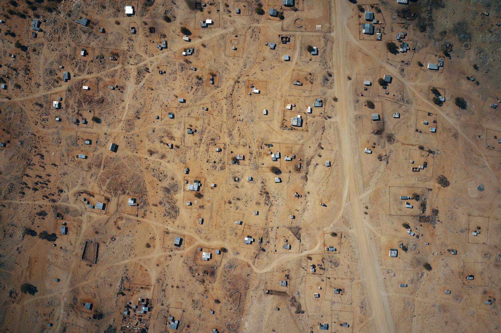 A drone image of scattered houses across the dry, sandy landscape