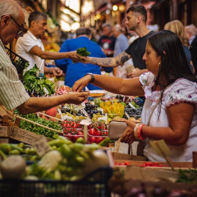 People shopping for fruit and vegetables at a busy market. Do you consciously think how to reduce food waste when you are food shopping? 