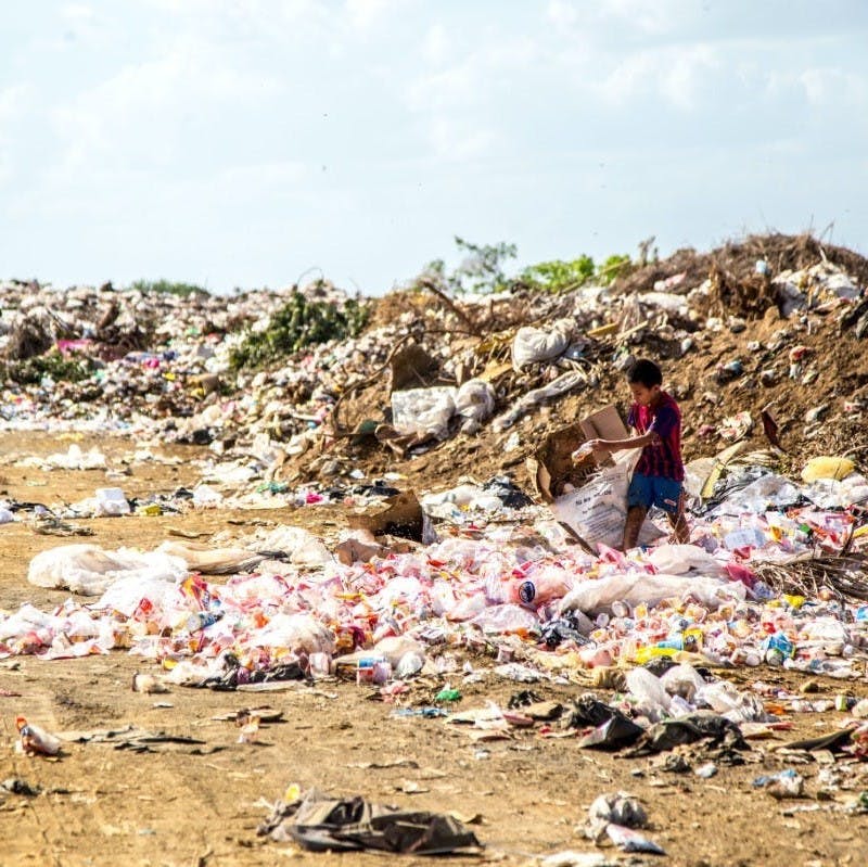 Child walking through landfill