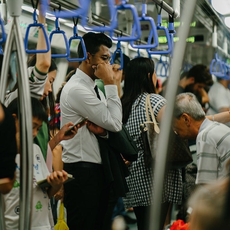 Passengers taking advantage of their commute by reading or listening to podcasts. Public transport is the stalwart of the green commute.