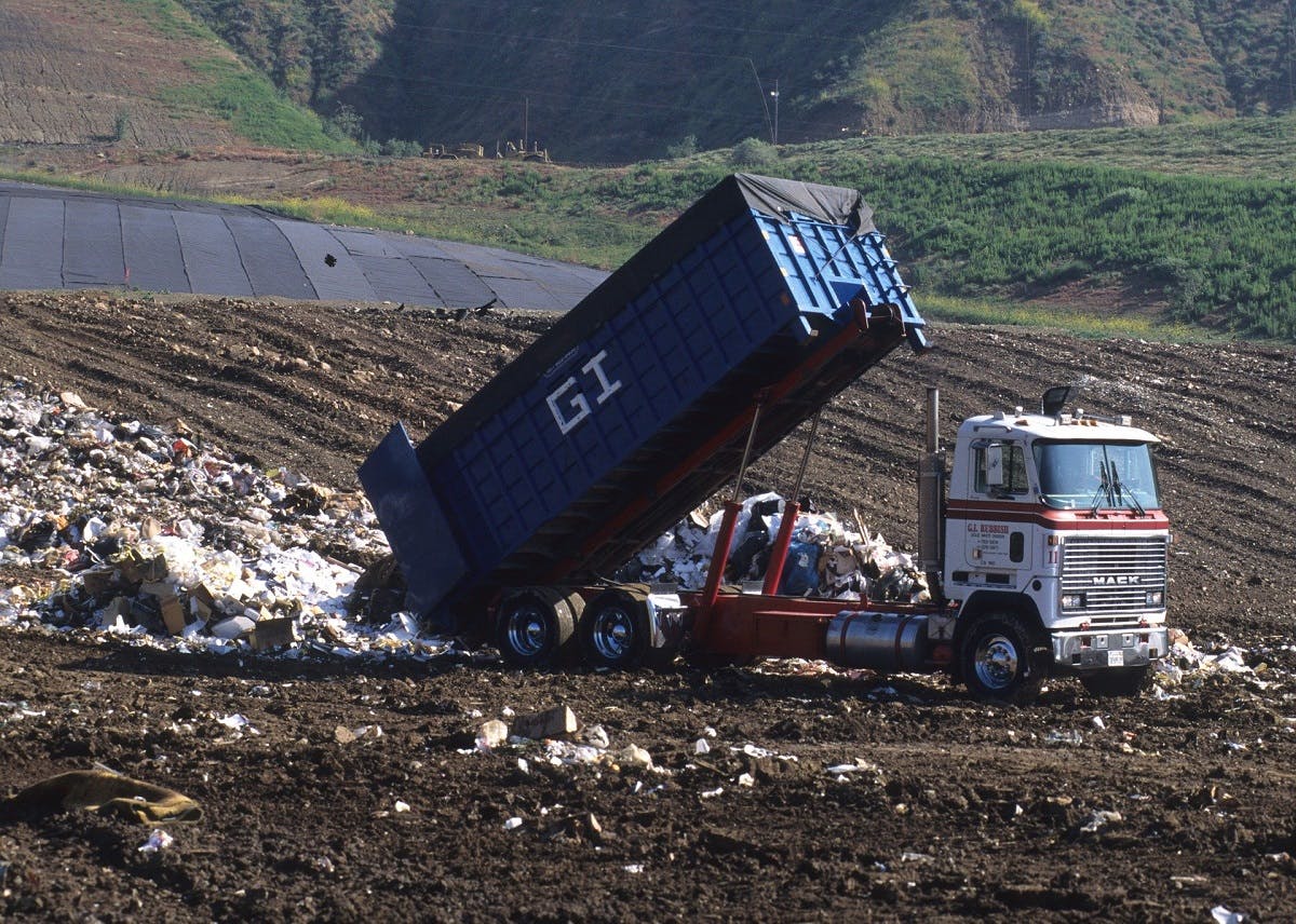 A truck dumping waste at a landfill site