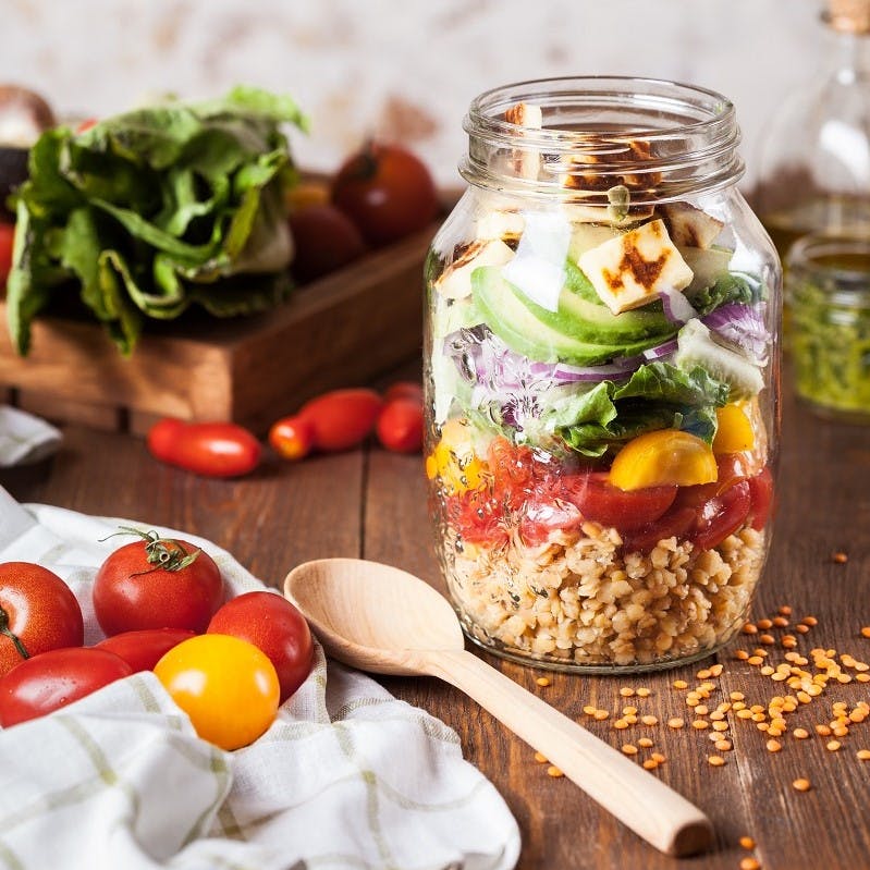 A jar filled with a variety of colourful foods. getting creative in the kitchen is one of many ways of how to reduce food waste at home. 