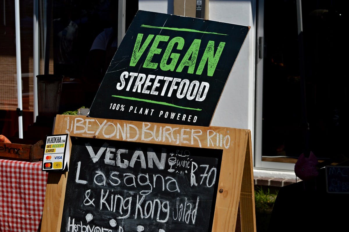 An A-board listing the day's specials, outside a vegan restaurant.