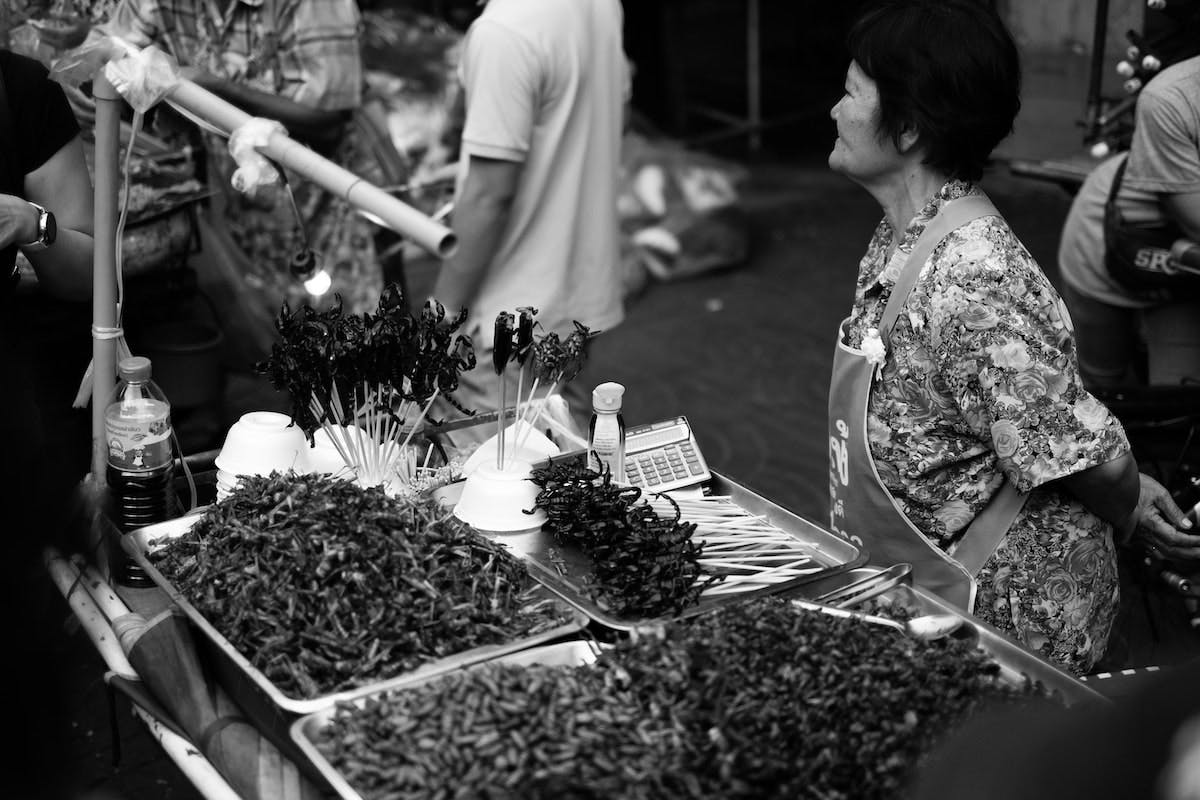A black and white image of an edible insect market in Asia.
