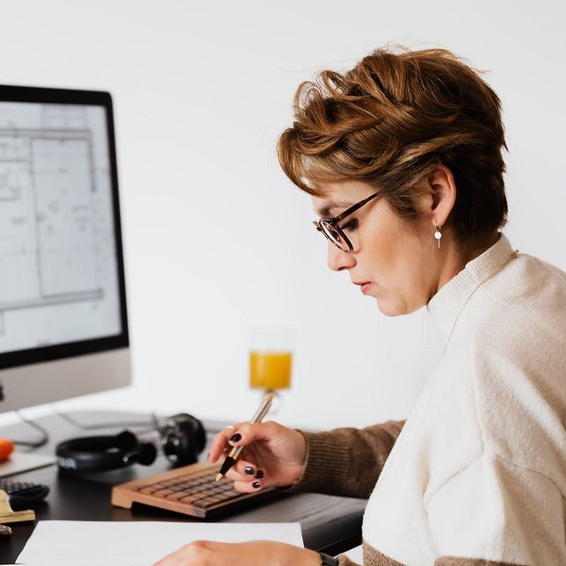 A lady reading online about home insulation hacks.