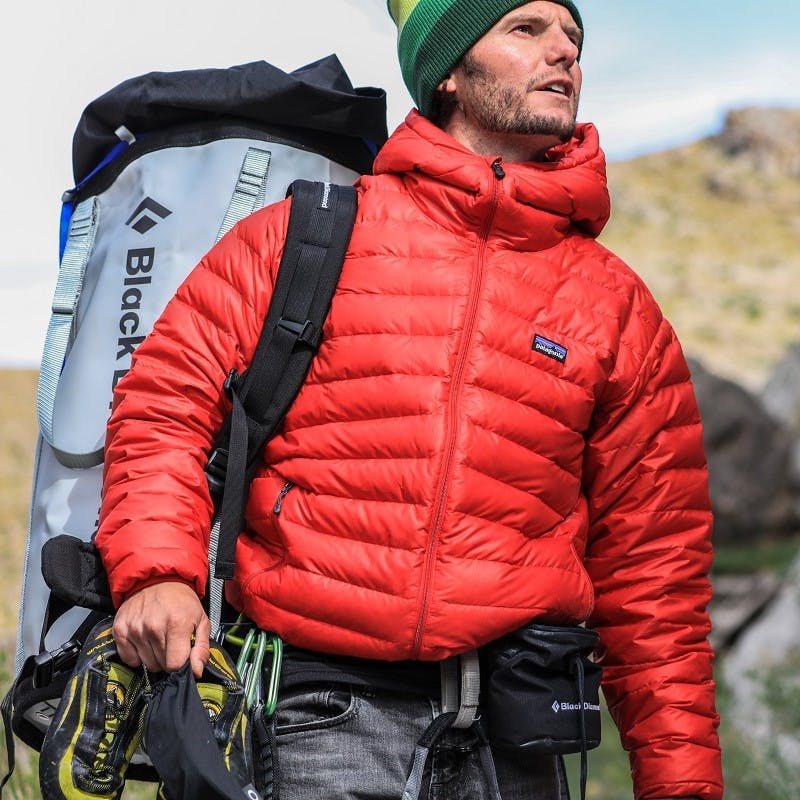A climber at the crag with climbing gear wearing a sustainable fashion brand. 