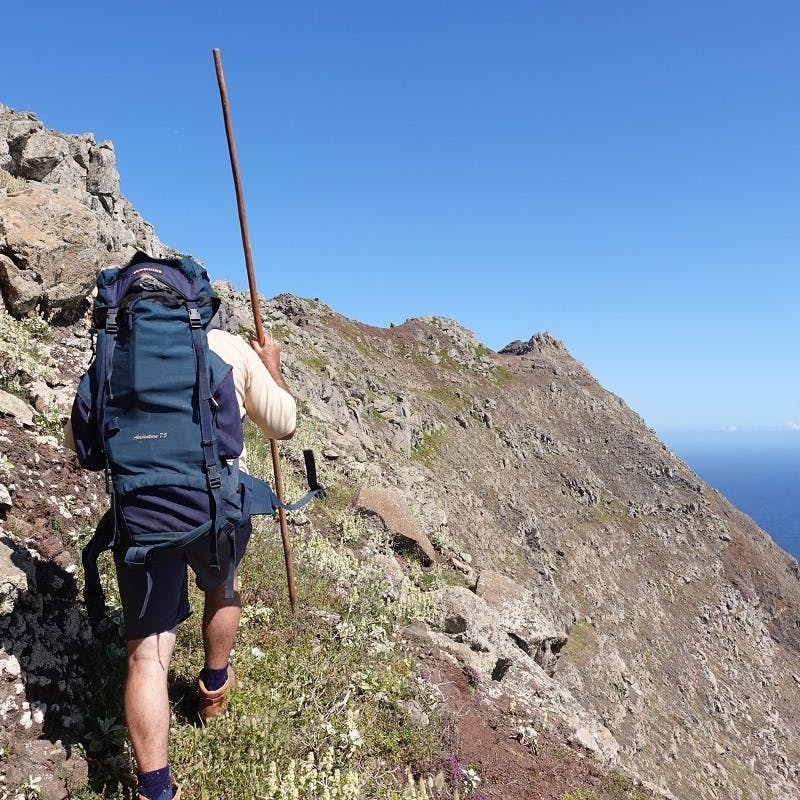 a conservation worker trekking over a mountain ridge.