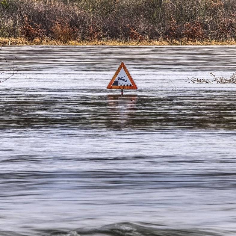 Flood water reaches top of road sign. Flood prevention is one of many benefits and reasons for rewilding.