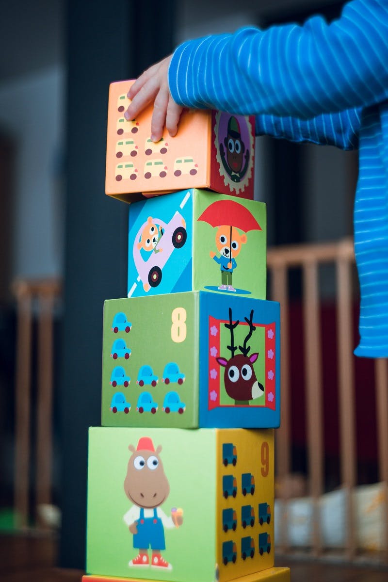 A toddler playing with toy blocks. A toy subscription is one of many ways to source eco friendly baby products.