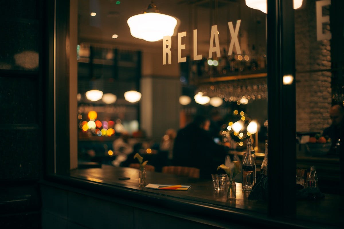 Looking in through a restaurant window at night. Being vegan means you don't have to miss out on eating out. Fortunately, vegan restaurants and cafes are popping up all over.