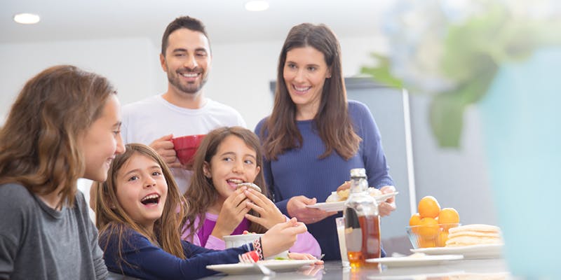 Family enjoying food together after setting their microwave clock to the correct time.
