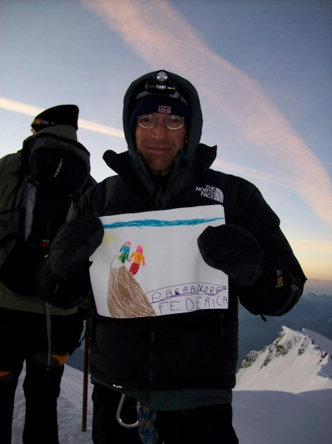 Andrea on top of Mont Blanc with a drawing of the daughter in his hands