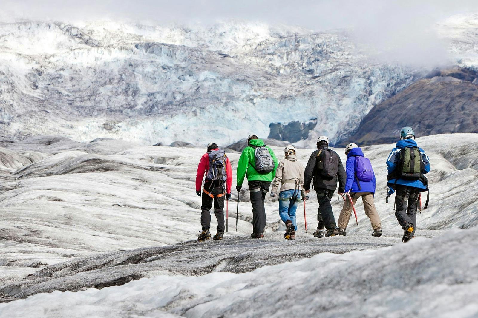 Group of hikers on the glacier going deeper into the valley towards the icefall