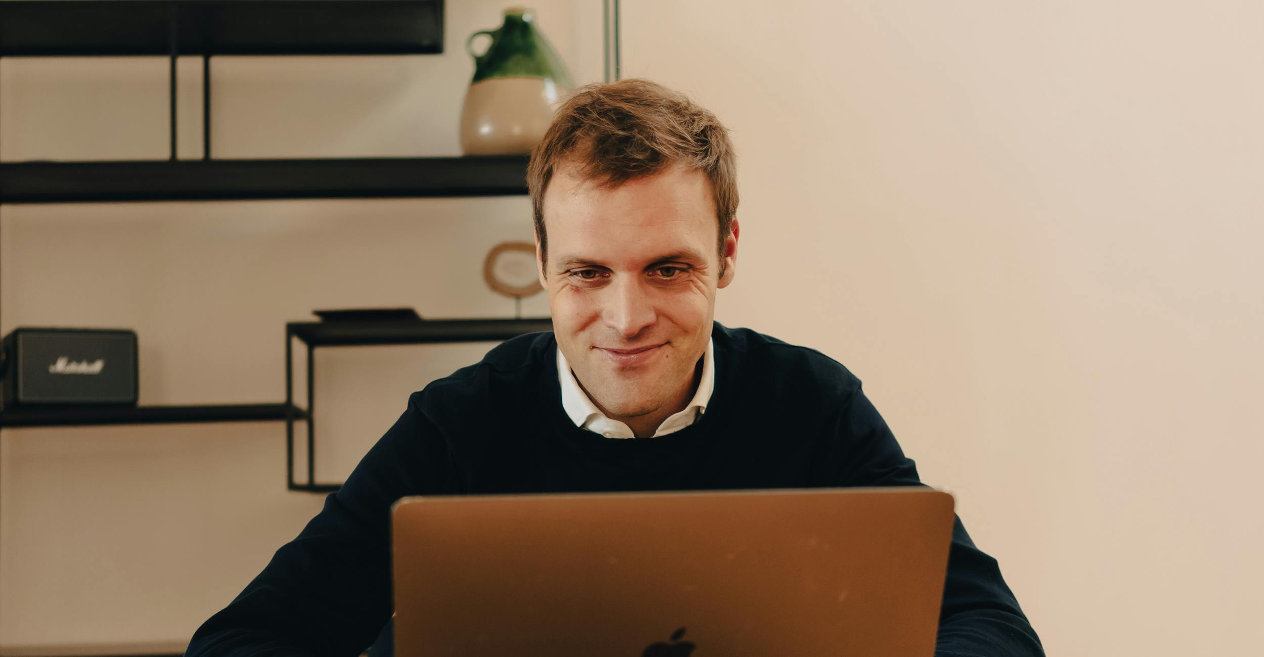 Man smiling at his laptop