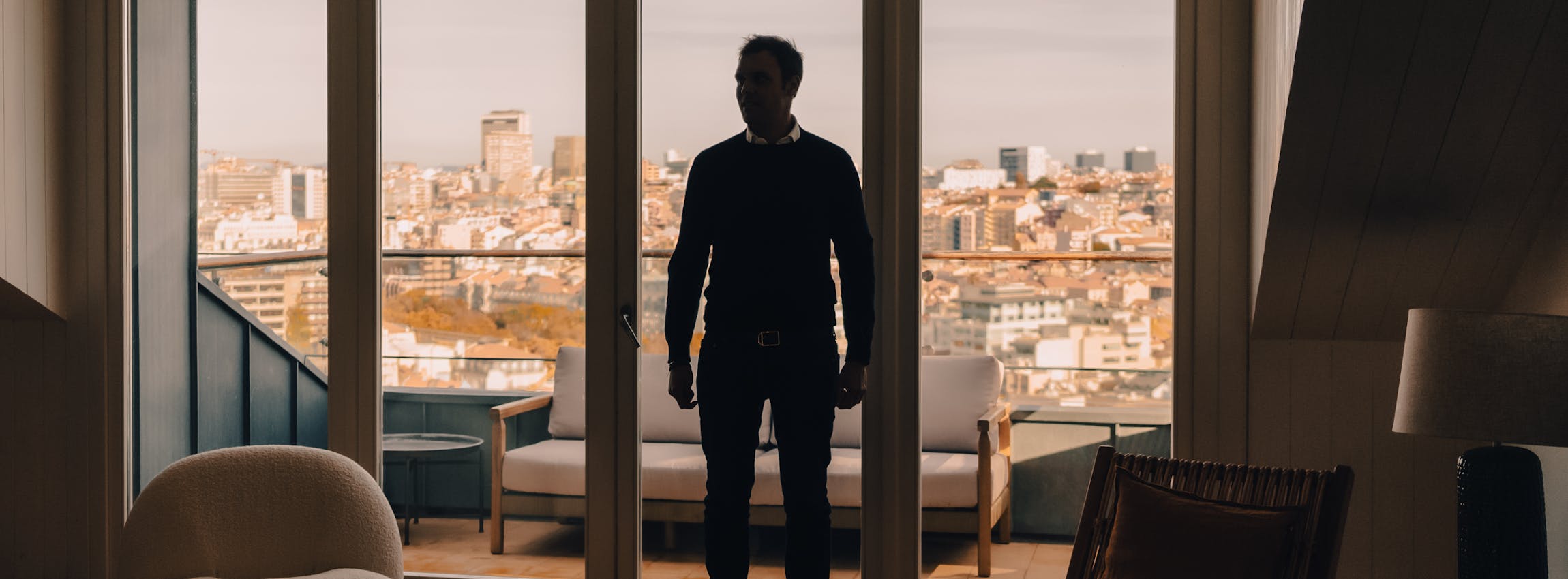 Man standing up inside his living room with a cascais view on the background