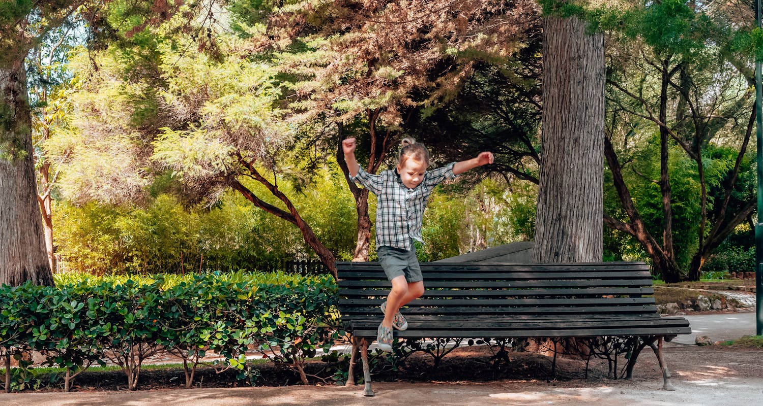 Boy leaping energetically from a bench in Parque Marechal Carmona, Cascais. Photo credit: Rita Ansone for Moviinn.