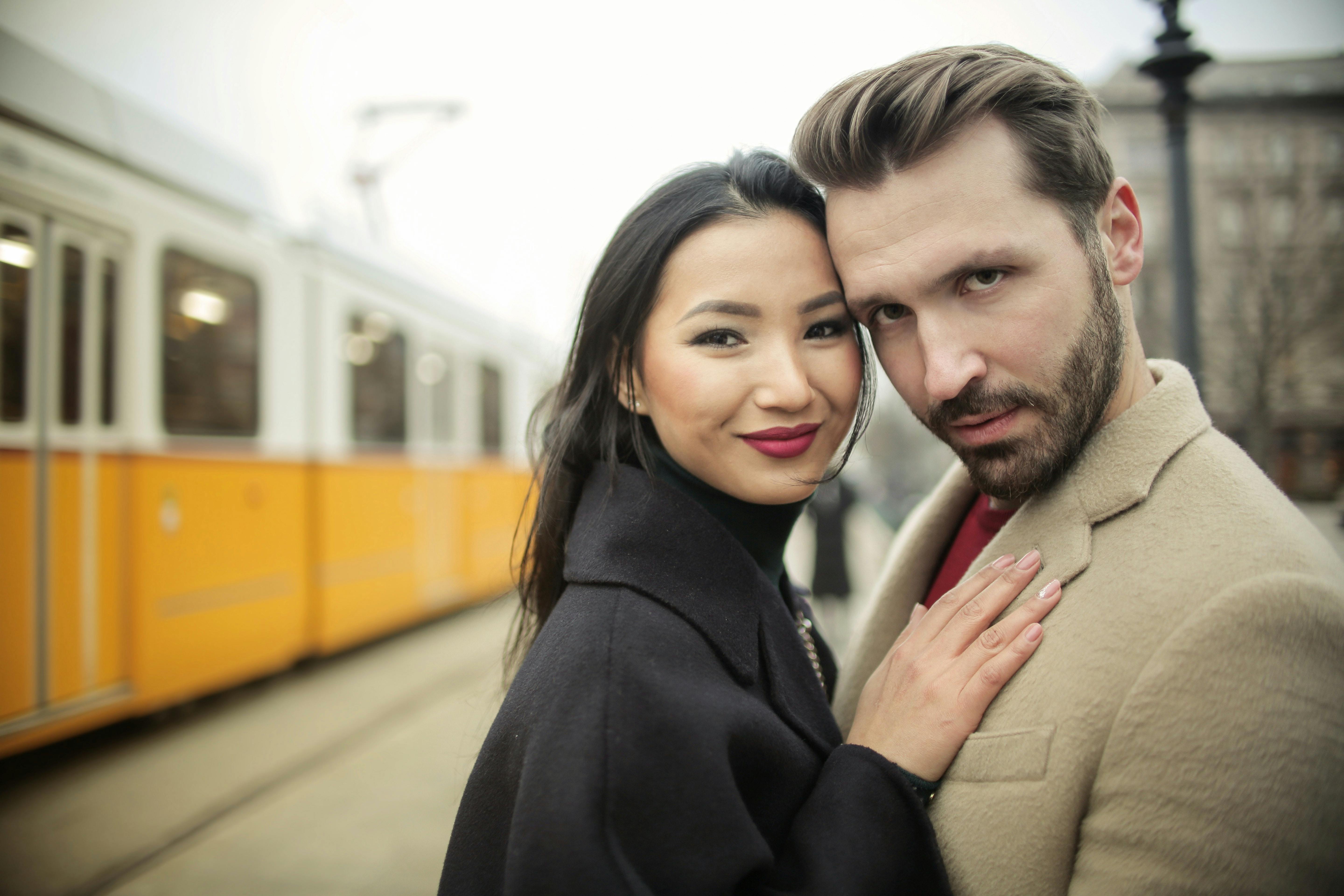 Couple posing next to an electric tram