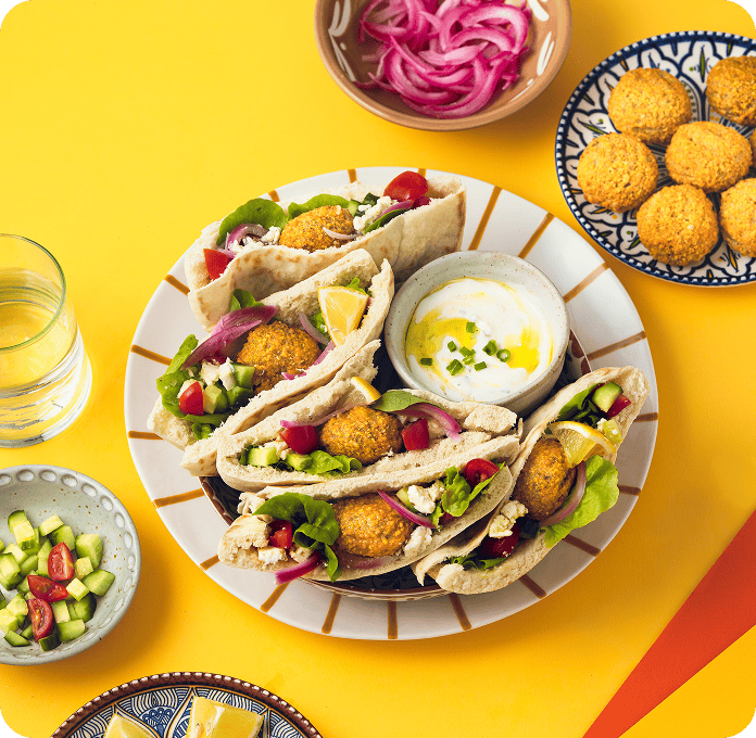 Recette de pain pita avec bouchées pois chiches, carottes et harissa, pickles d'oignons et sauce blanche