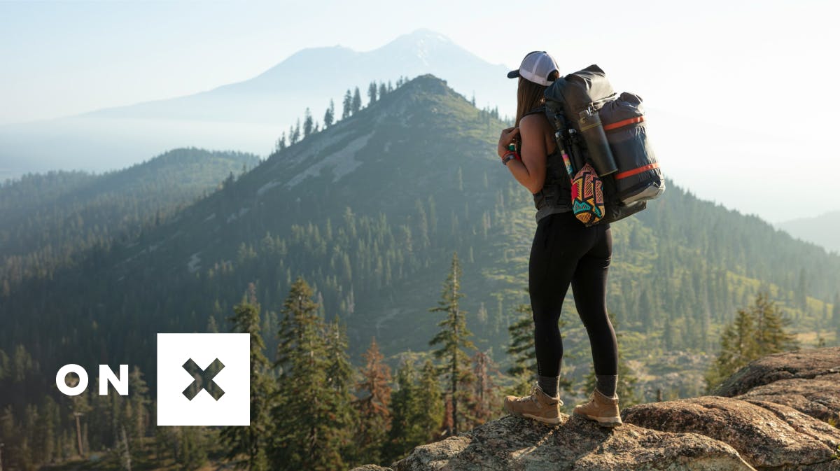 A stock image of a woman hiking with the onX logo