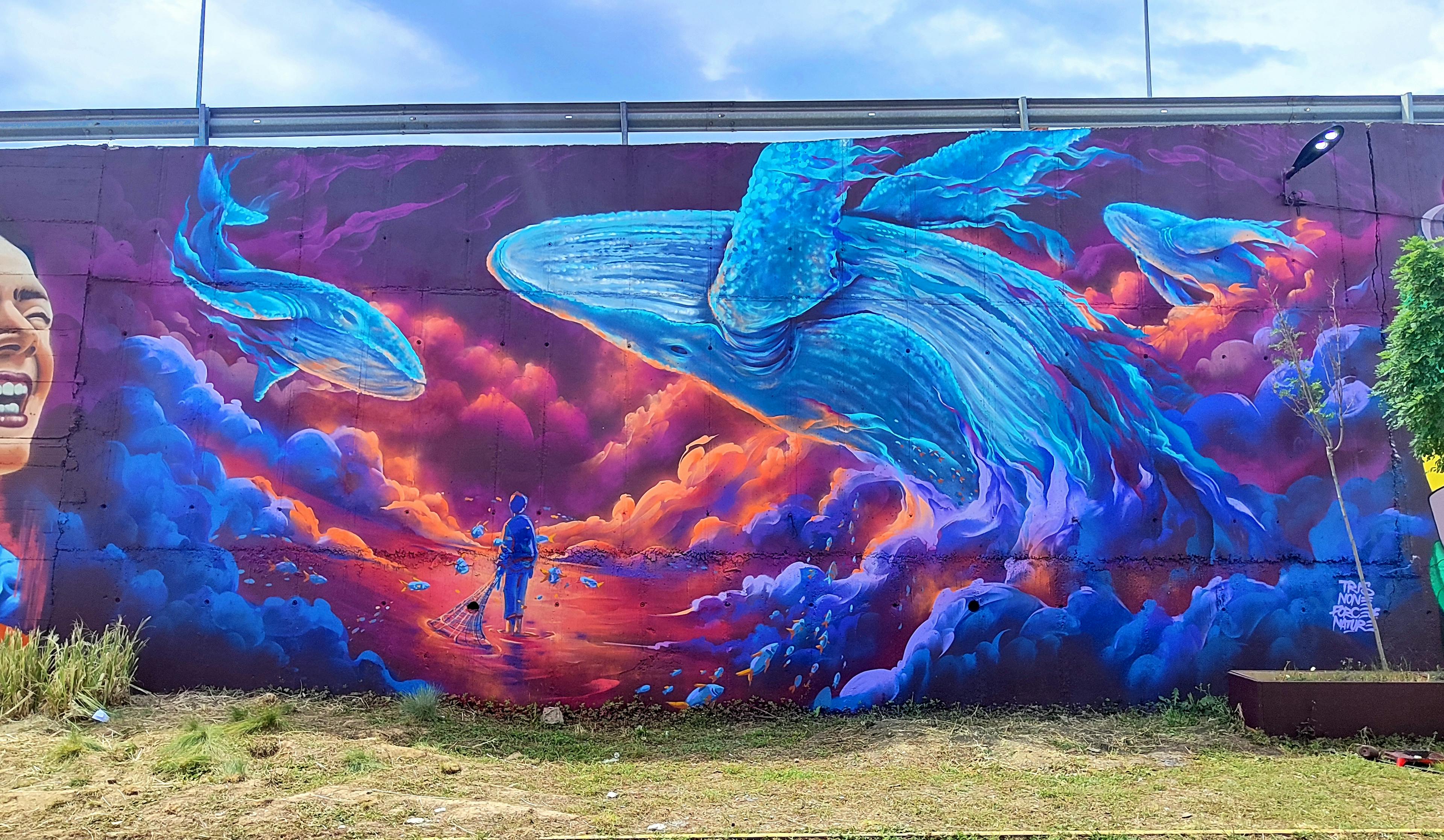 Mural painting Pristina, Meeting of styles Kosovo, Force of Nature (GER), None(MK), Tris (FR), whales jumping, clouds, little fisherman looking up, flying fishes