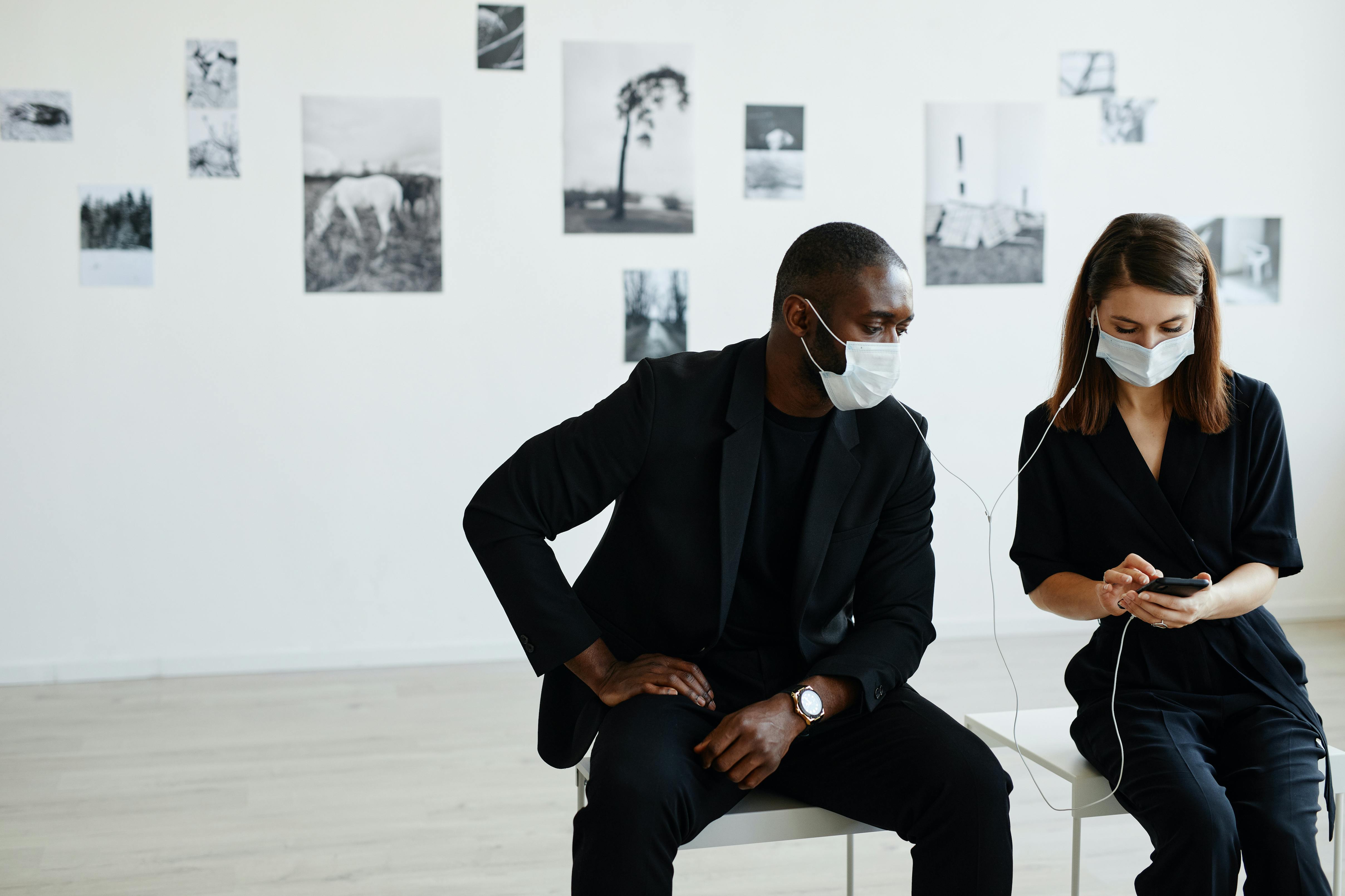 Couple moderne portant des masques dans une galerie d'art