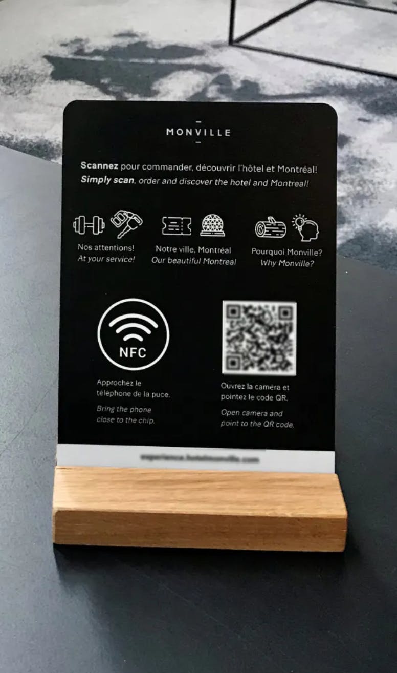 Une affichette de l'Hotel Monville Invitant a scanner le code QR et la puce NFC
