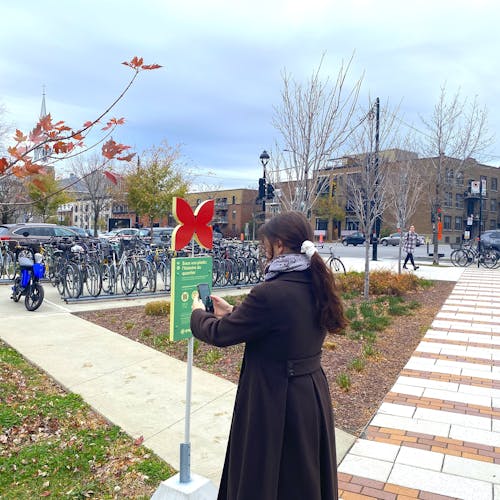 Jeune femme scannant un panneau interactif en ville