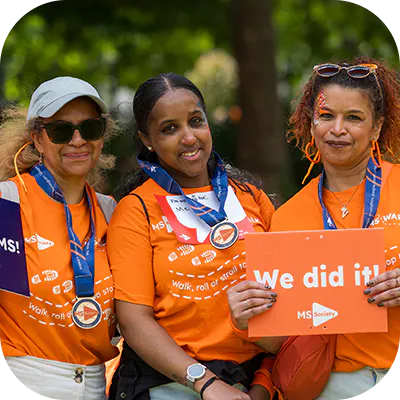 Three charity event participants smiling in MS Society t-shirts.