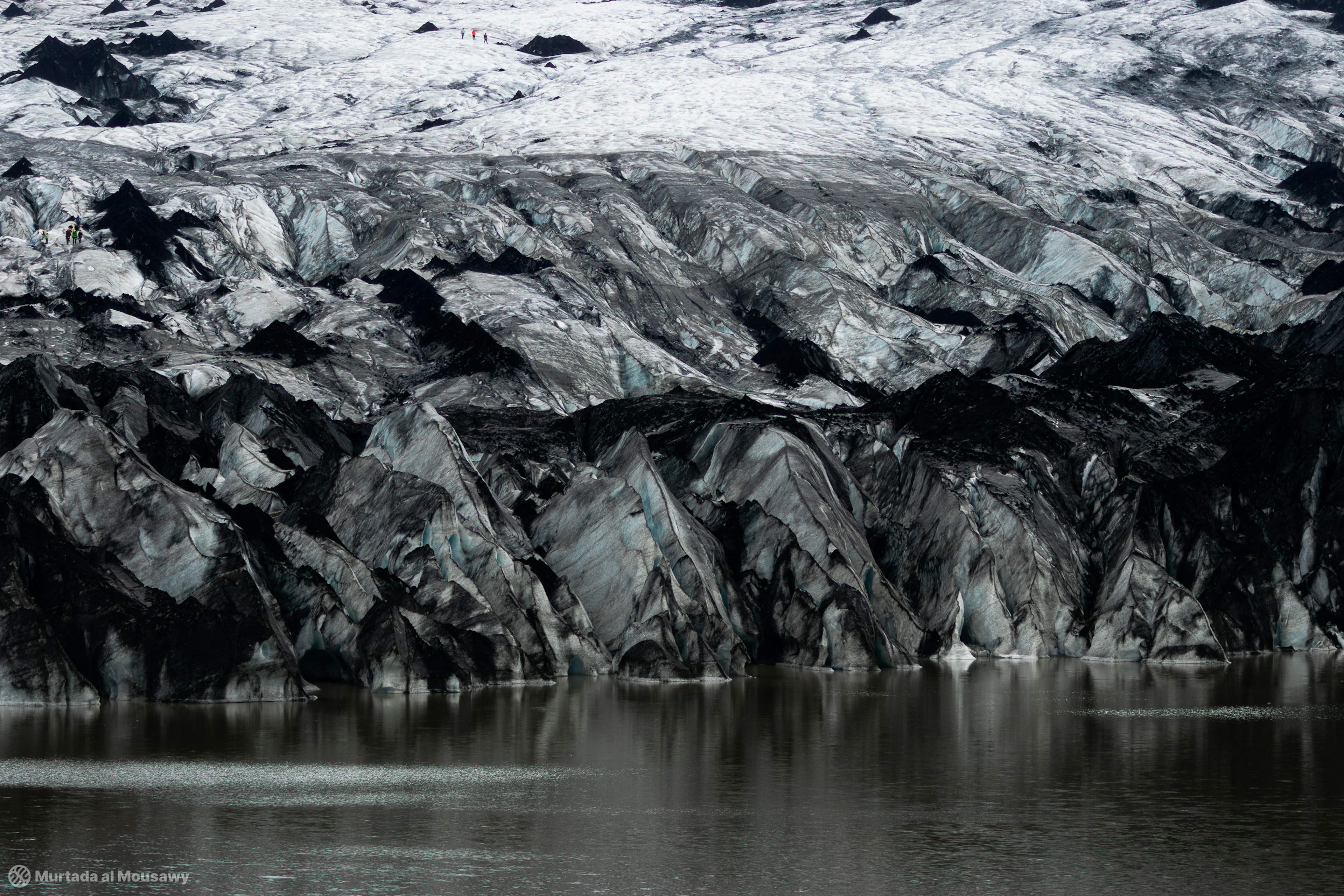 Photo of large glacier Snæfellsjökull in Iceland with people walking on it, showing its scale.