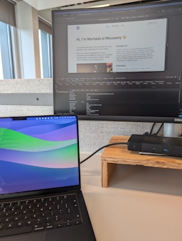 Laptop and monitor screen showing development of Murtada's website.