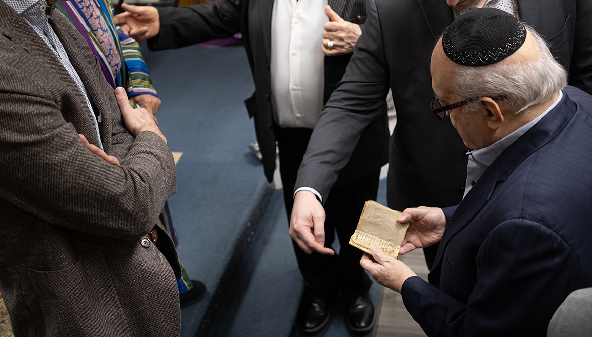 Members of Congregation Anshei Shalom of Jamaica Estates handle a replica of the ALQ