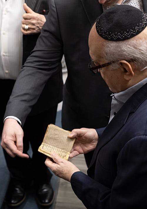 Members of Congregation Anshei Shalom of Jamaica Estates handle a replica of the ALQ