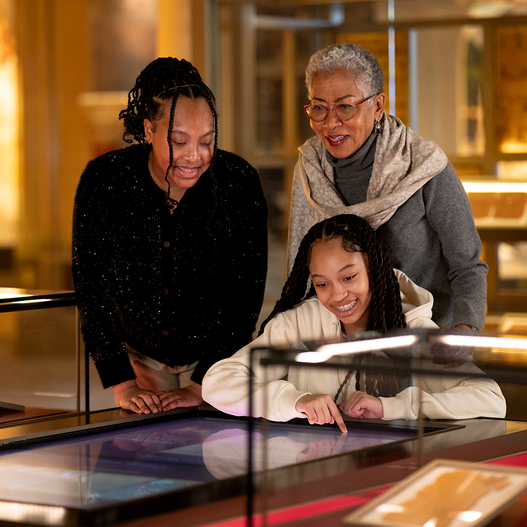 Family of three viewing artifacts on the History floor.