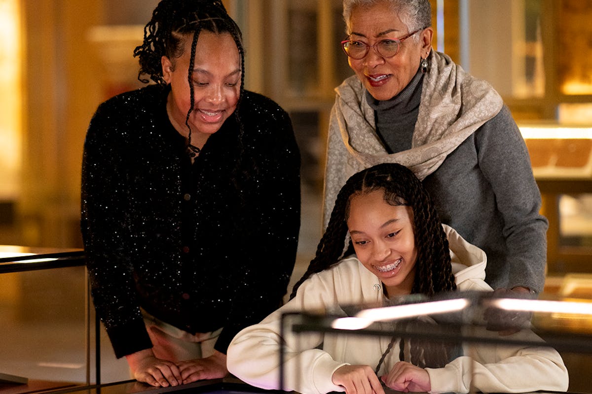 Family of three viewing artifacts on the History floor.
