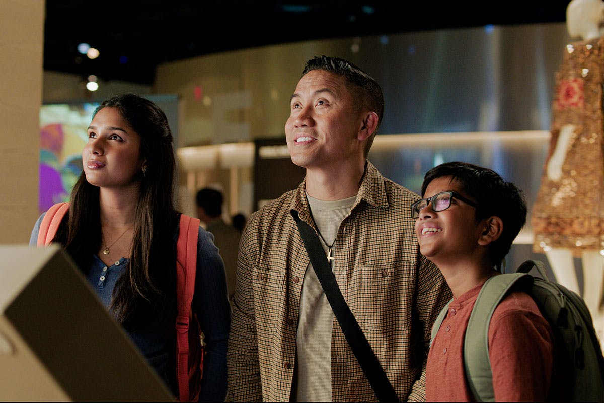 Family of three interacting with exhibits at the museum.