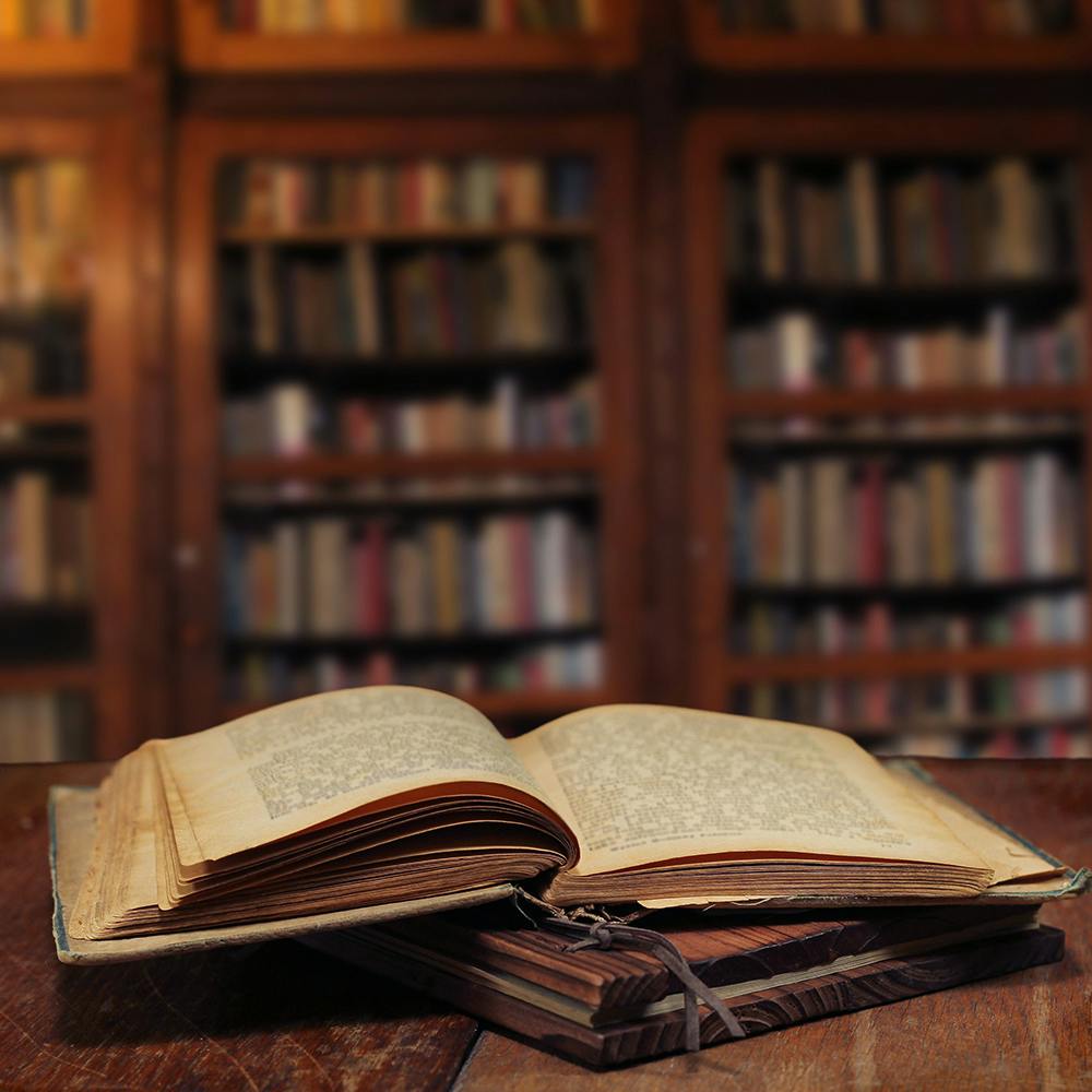 Open book on table in library setting.