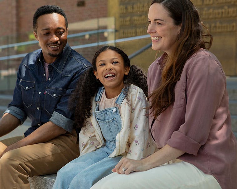 Three people sitting right outside the museum