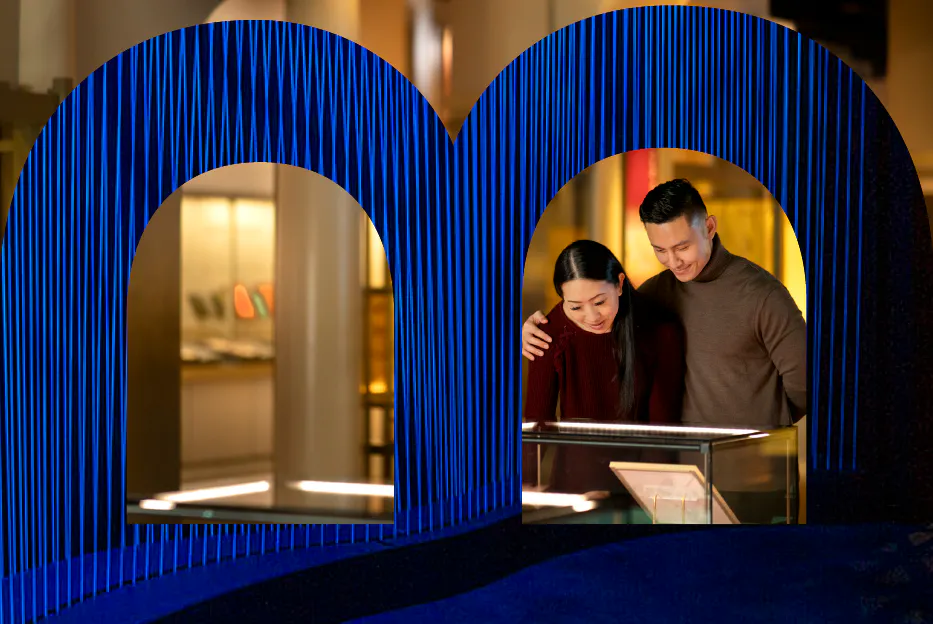 A man and a women looking at an exvhibit in the bible with the MOTB logo overlayed.
