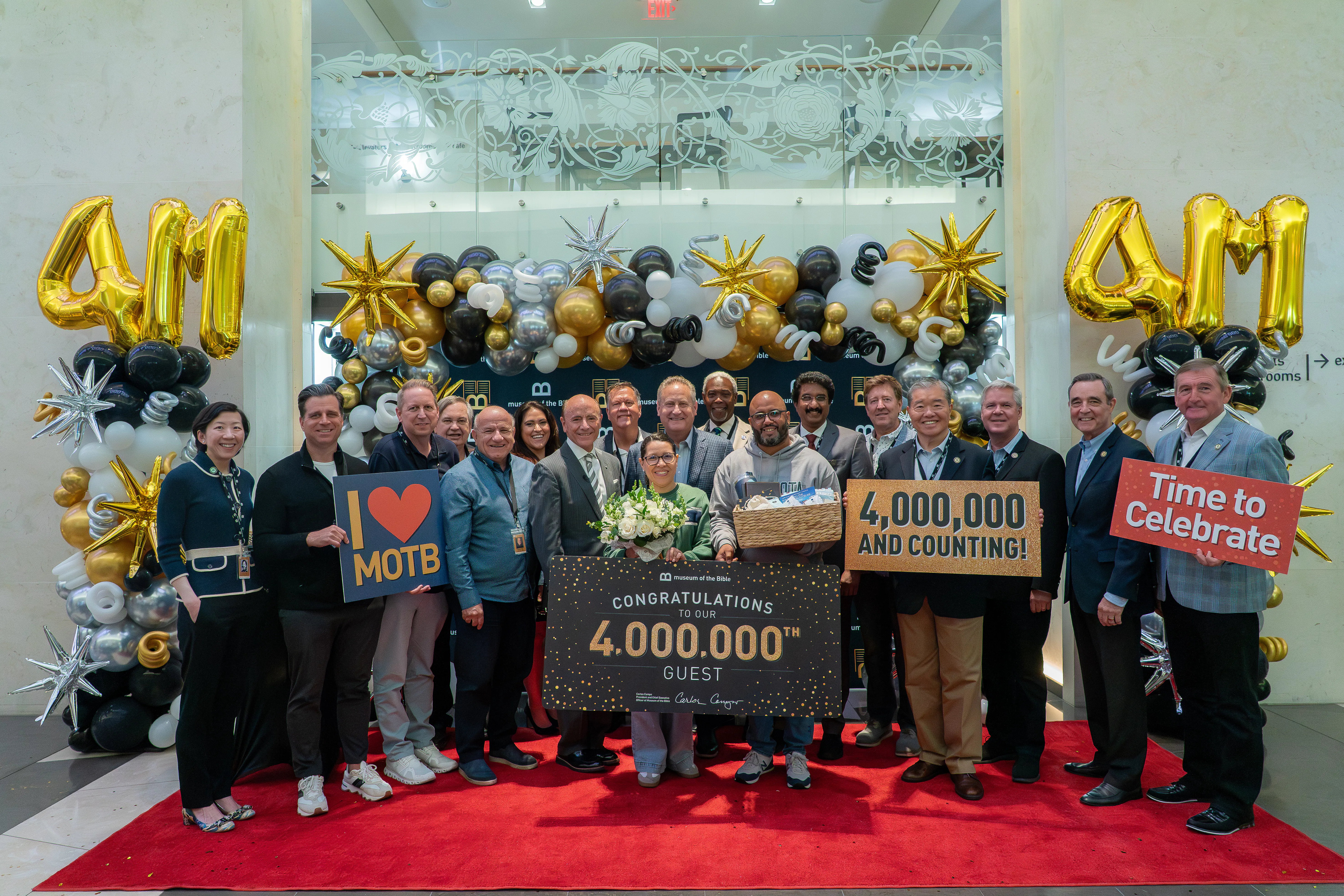 Group of individuals celebrating the 4 millionth guest