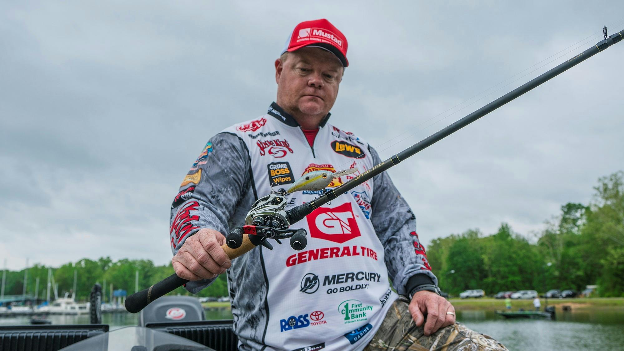 Portrait photo of American pro staffer Mark Rose holding up a rod with a balsa bait.