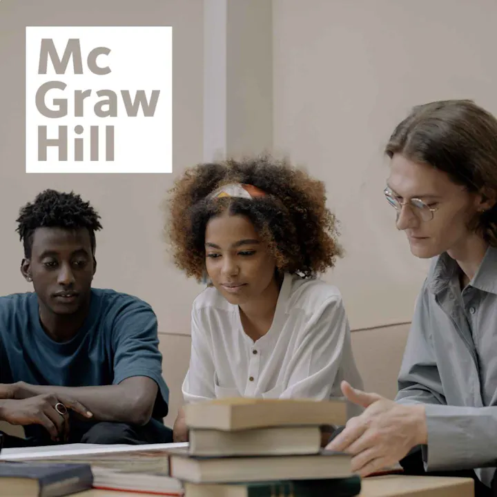 3 students all leaning over a set of books studying together with a white McGraw Hill logo in the top left corner