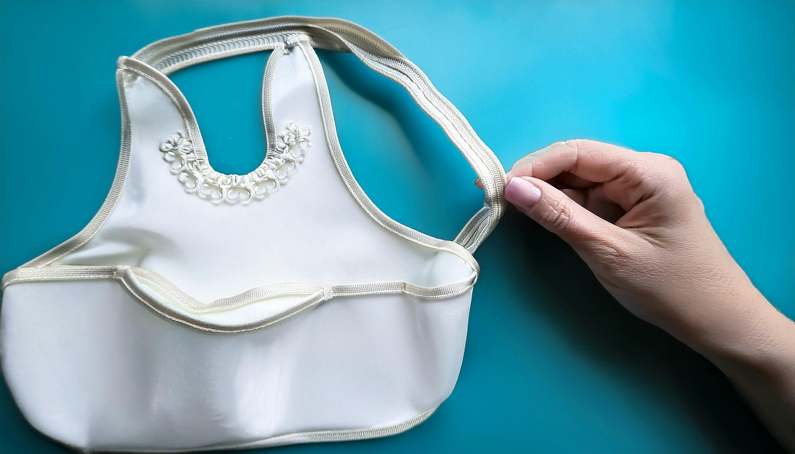 A hand holding an adult bib