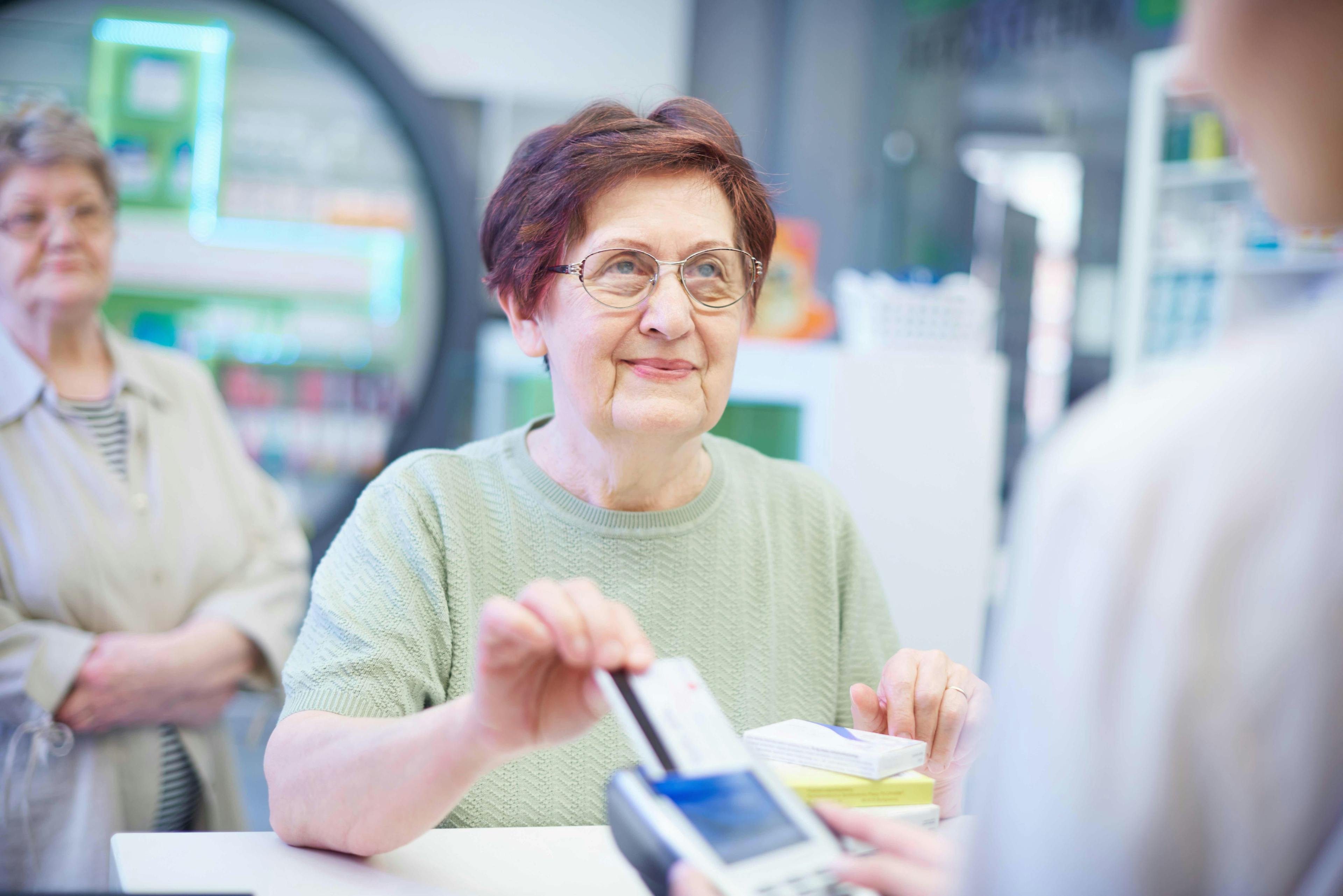 Woman paying at the register at pharmacy