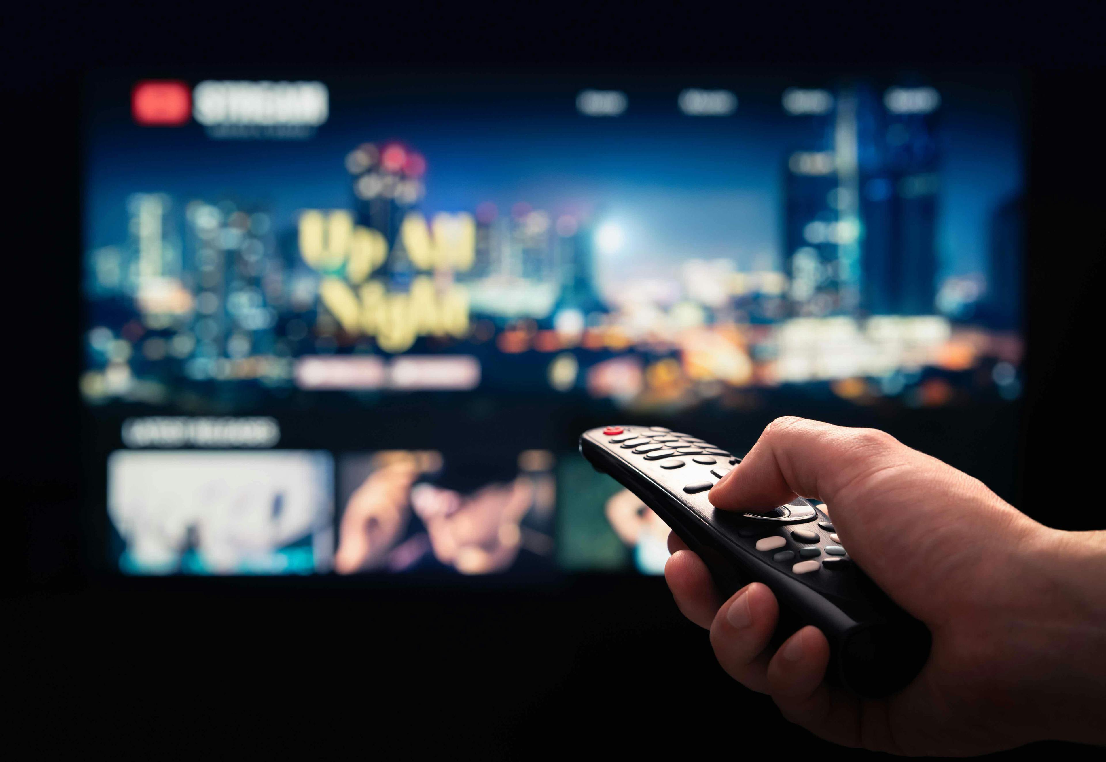 Person holding remote to TV