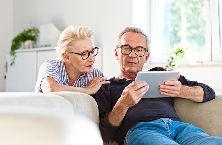 Couple on the couch looking at tablet