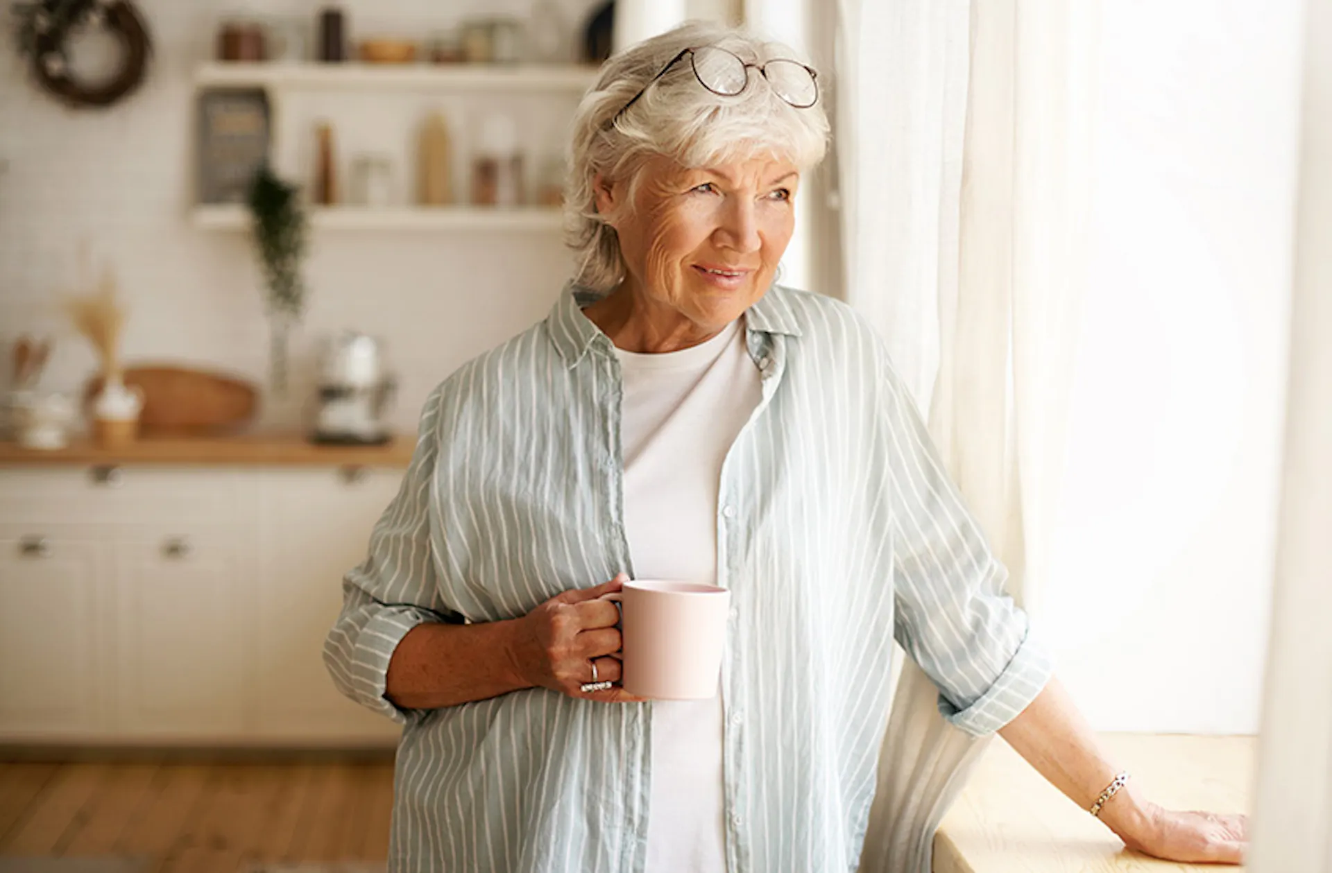 woman in kitchen drinking coffee