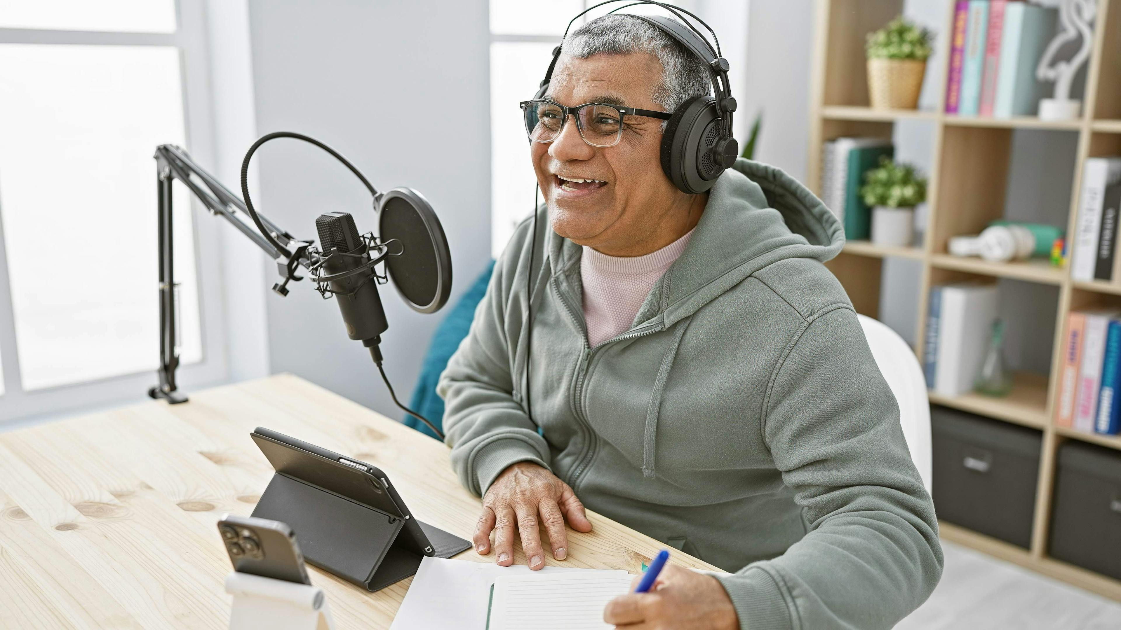 Smiling senior man with headphones speaking into a microphone