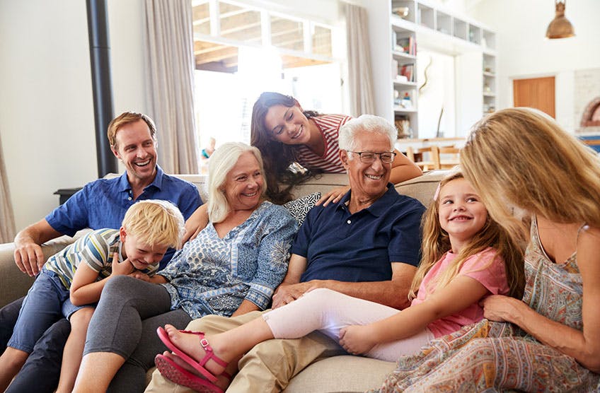 Family smiling and sitting together on the couch