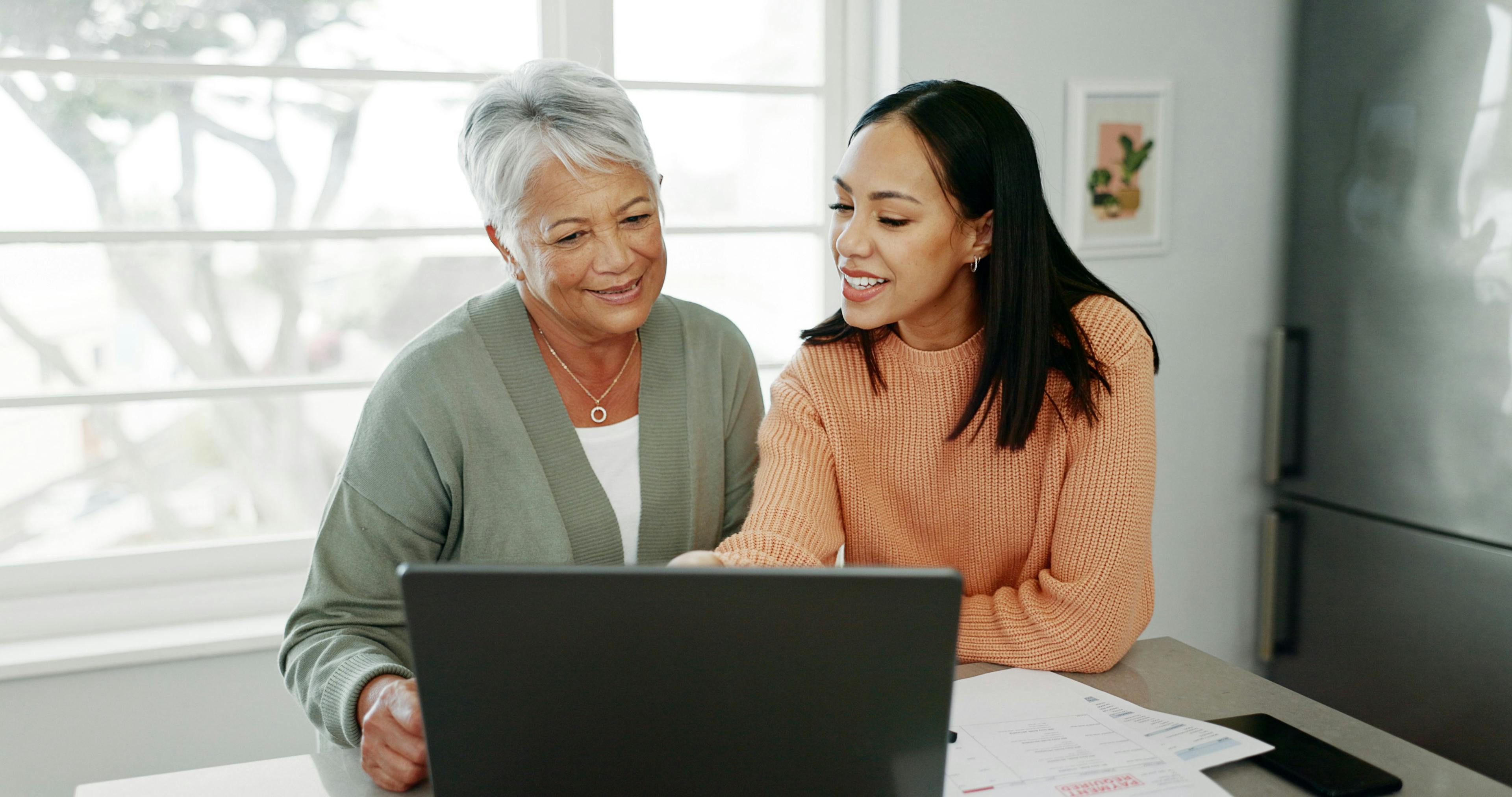 Daughter and mother on computer comparing plans