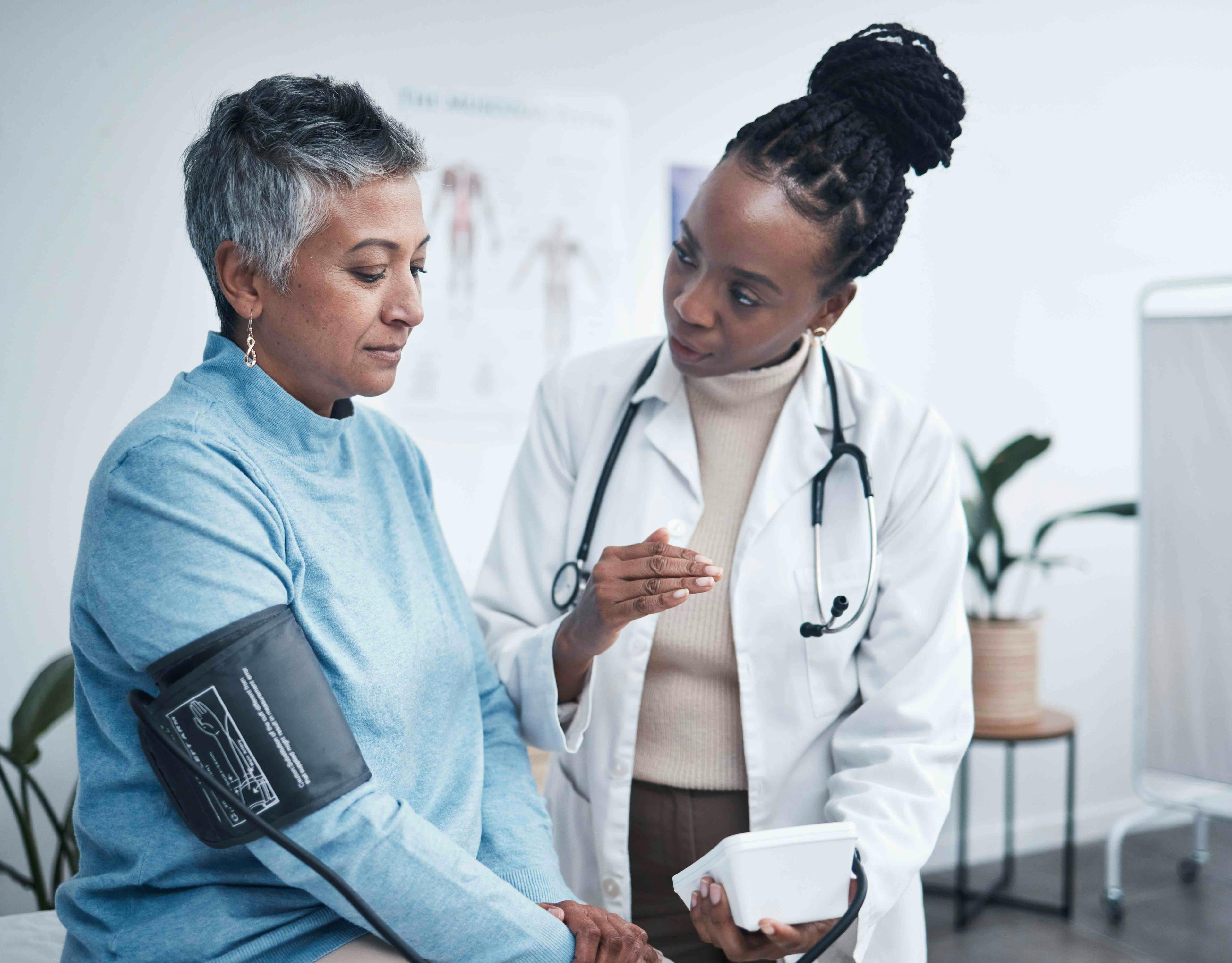 Doctor with patient taking blood pressure
